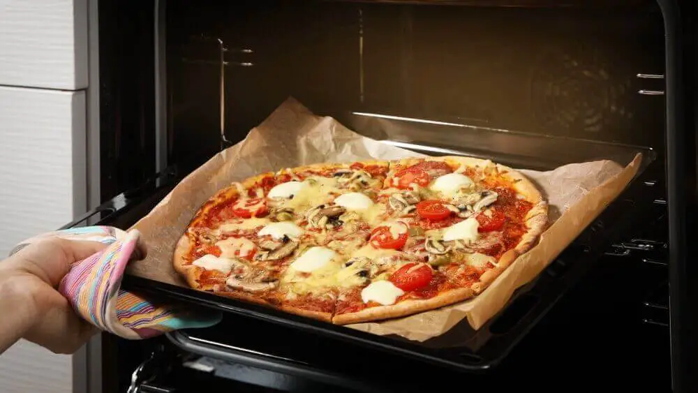 pizza baking on parchment paper