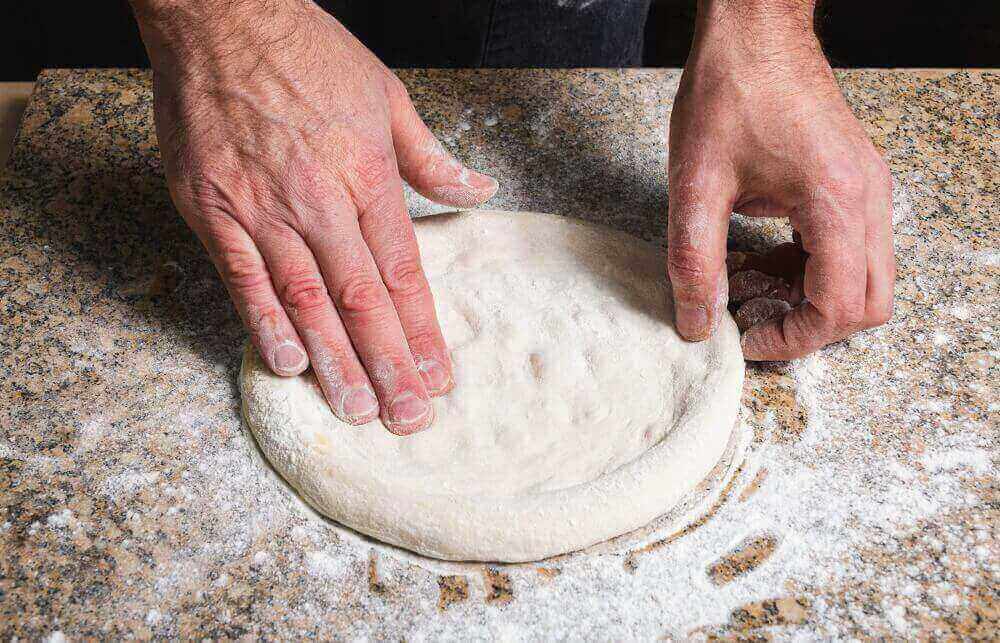 rolling pizza by hands