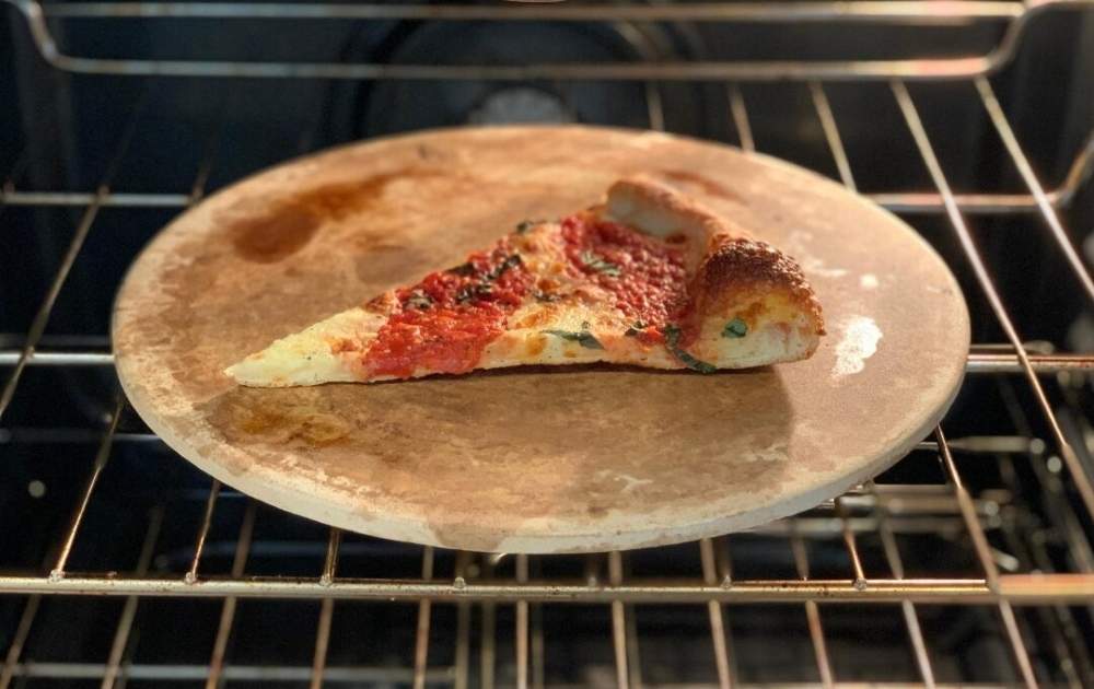 A pizza slice on a pizza stone